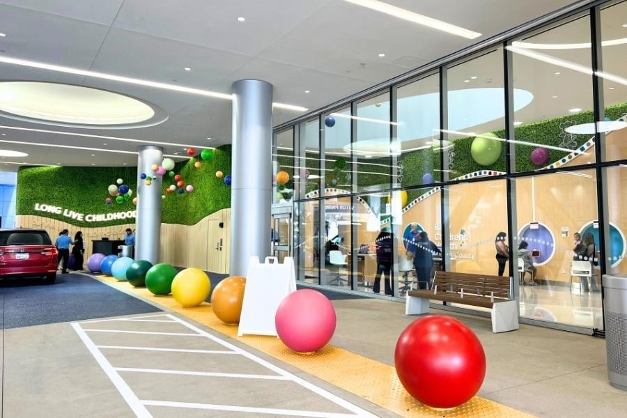 Exterior view of Rady Children’s Health Orange County with vibrant reindeer moss walls, playful colorful spheres at the hospital entrance.
