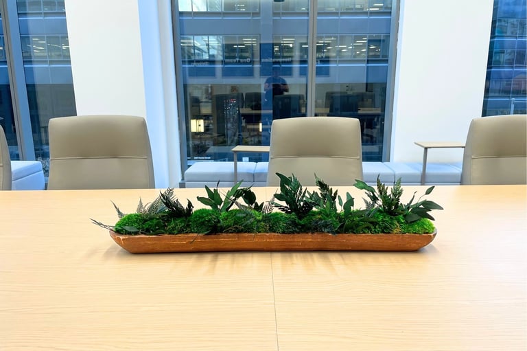 Long wooden tray of preserved moss and foliage on a conference table