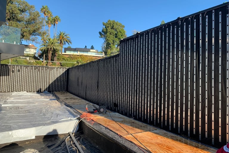 Black waterproofing and vertical rails installed along the living wall frame before planting