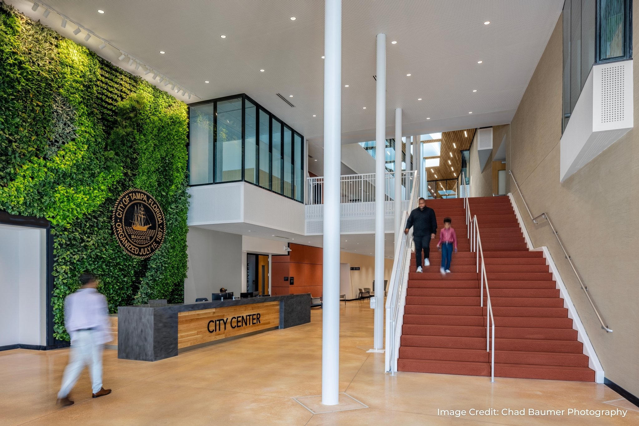 Indoor living wall with the City of Tampa seal beside the reception desk in the building lobby