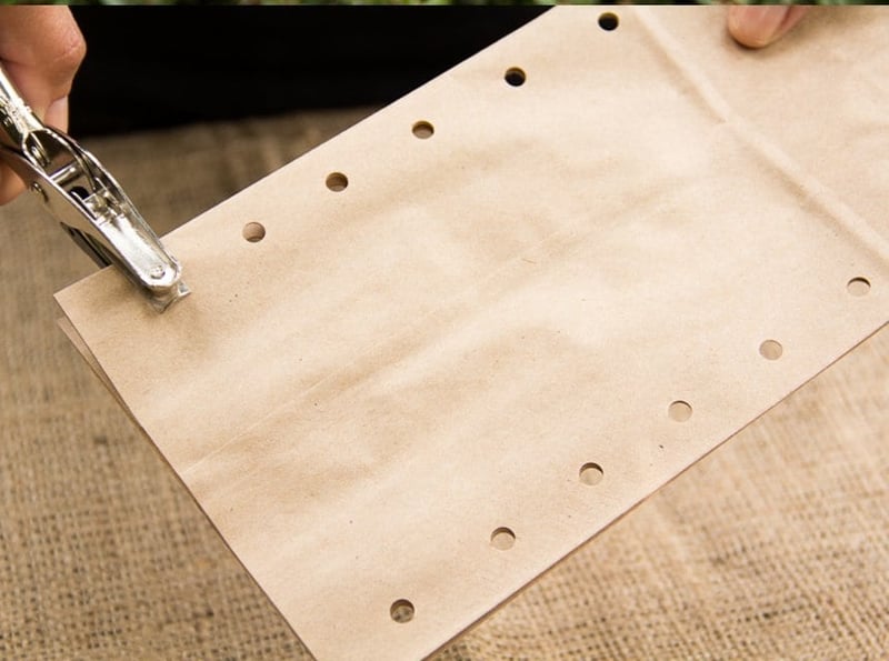 Punching holes in a brown paper bag 