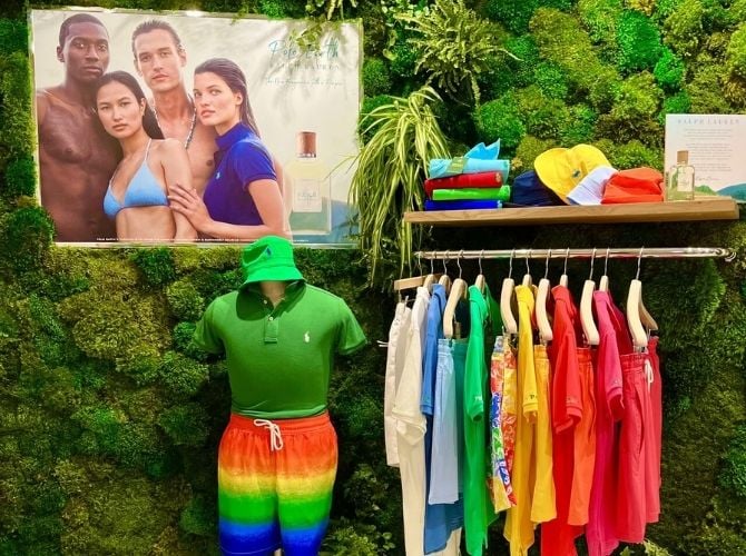 Clothing display inside the Ralph Lauren pop-up store with a preserved moss wall behind it