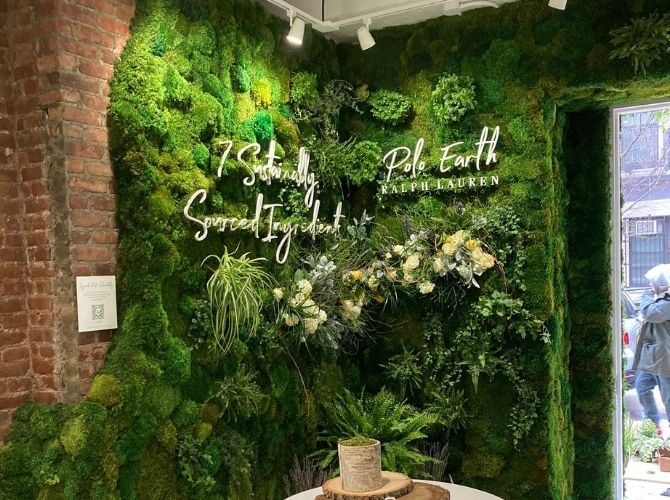 Signage on a preserved moss wall with a live edge that fades into a brick wall