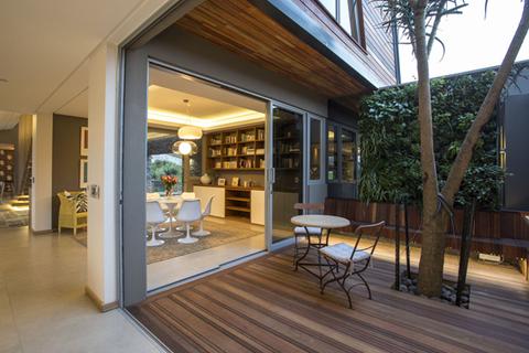 an indoor-outdoor living space with a greenwall on the patio