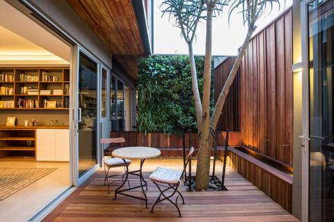 An outdoor patio space with a greenwall as a background accent 