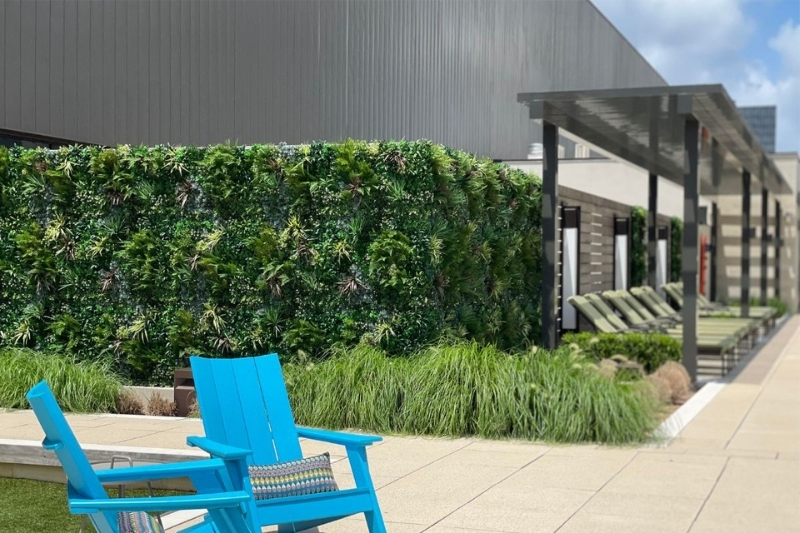Faux plant panel greenwall around the fence of a building