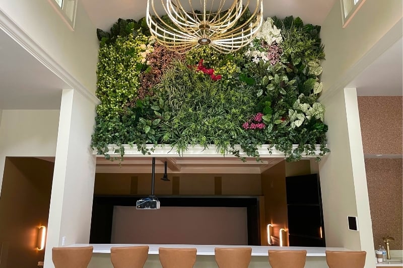 Lush artificial greenwall in an alcove space above a bar in a residence.